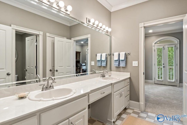 bathroom featuring baseboards, crown molding, french doors, and a sink