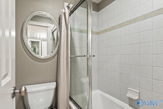 bathroom with toilet and bath / shower combo with glass door