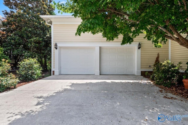 garage featuring concrete driveway