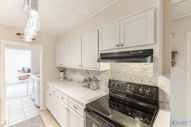 kitchen with white cabinets, black electric range oven, under cabinet range hood, and separate washer and dryer