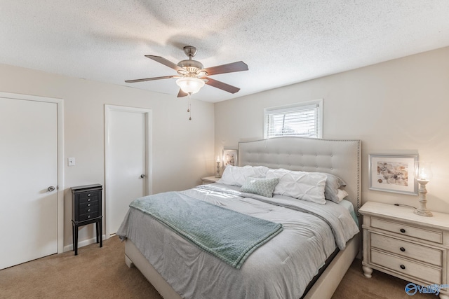 carpeted bedroom featuring a textured ceiling and a ceiling fan