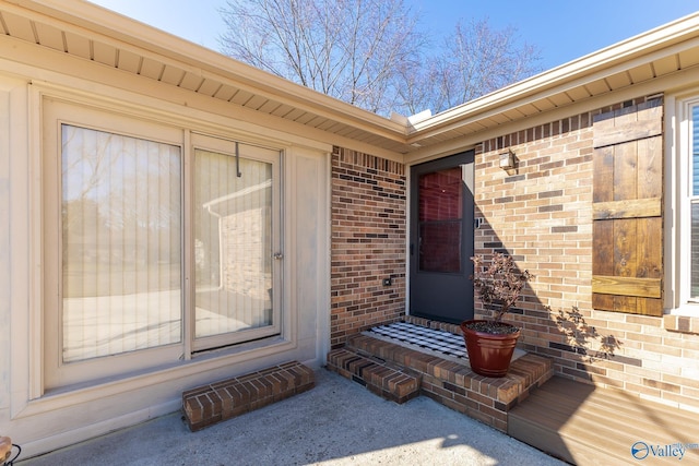 doorway to property featuring brick siding