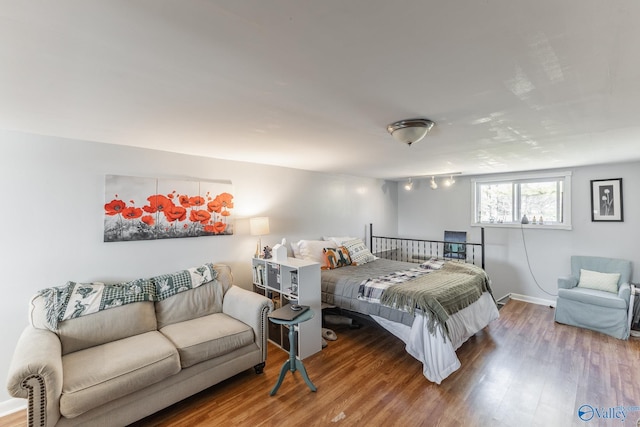 bedroom with baseboards and wood finished floors