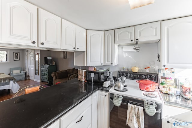 kitchen featuring electric stove, dark wood finished floors, and white cabinetry