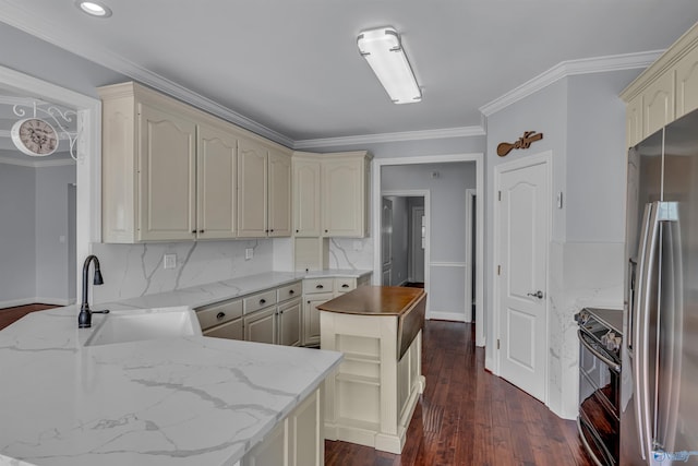 kitchen with decorative backsplash, sink, range with electric cooktop, stainless steel fridge, and cream cabinets