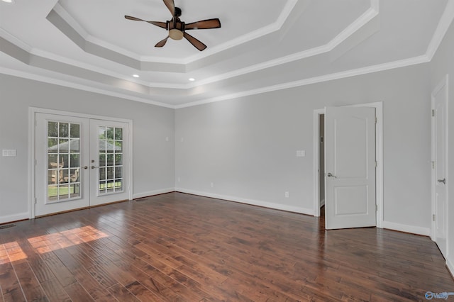 spare room featuring dark wood-type flooring, ornamental molding, a raised ceiling, and french doors