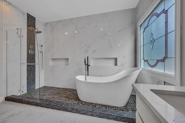 bathroom with tile walls, vanity, and shower with separate bathtub