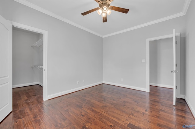 unfurnished bedroom with ceiling fan, a walk in closet, a closet, and dark hardwood / wood-style floors