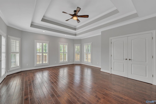 spare room featuring dark hardwood / wood-style floors, crown molding, and a raised ceiling