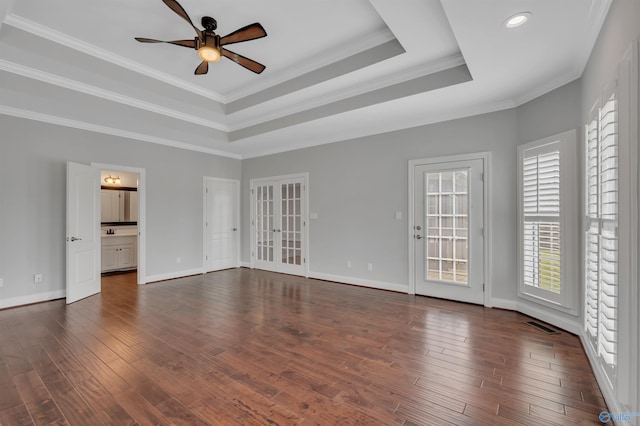 unfurnished room featuring ceiling fan, crown molding, dark hardwood / wood-style floors, and a tray ceiling