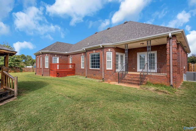 rear view of property with a lawn and central air condition unit