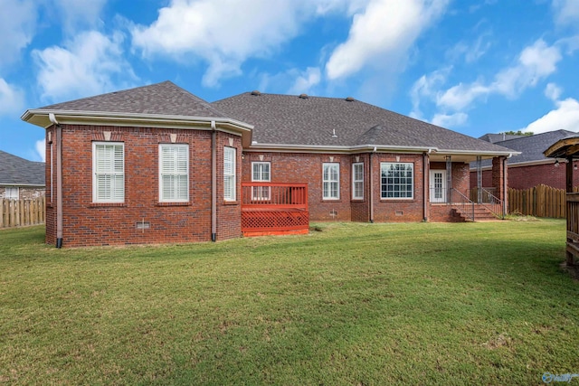 back of property with a wooden deck and a yard