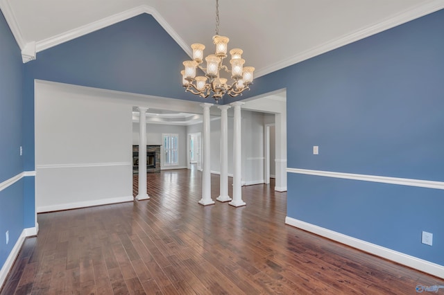 unfurnished dining area featuring decorative columns, dark hardwood / wood-style flooring, crown molding, and a stone fireplace