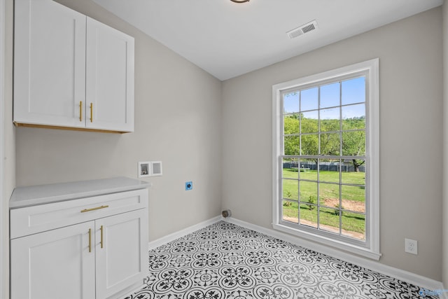 laundry area with hookup for an electric dryer, a healthy amount of sunlight, visible vents, and baseboards
