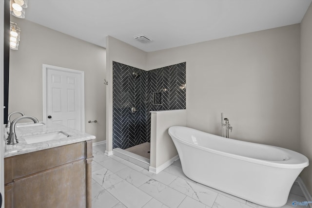 bathroom with marble finish floor, a freestanding bath, vanity, baseboards, and walk in shower