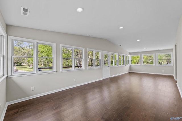 unfurnished sunroom with lofted ceiling, baseboards, wood finished floors, and visible vents