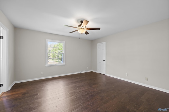 unfurnished room featuring baseboards, visible vents, dark wood-style floors, and ceiling fan