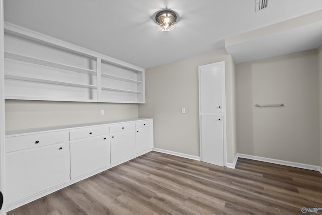 interior space with visible vents, baseboards, and dark wood finished floors