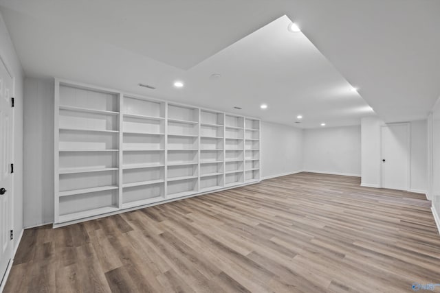 finished below grade area featuring baseboards, wood finished floors, recessed lighting, and built in features