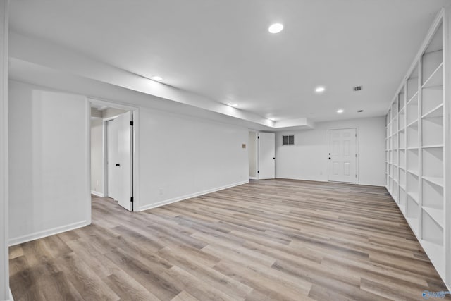 finished below grade area with baseboards, light wood-style flooring, visible vents, and recessed lighting