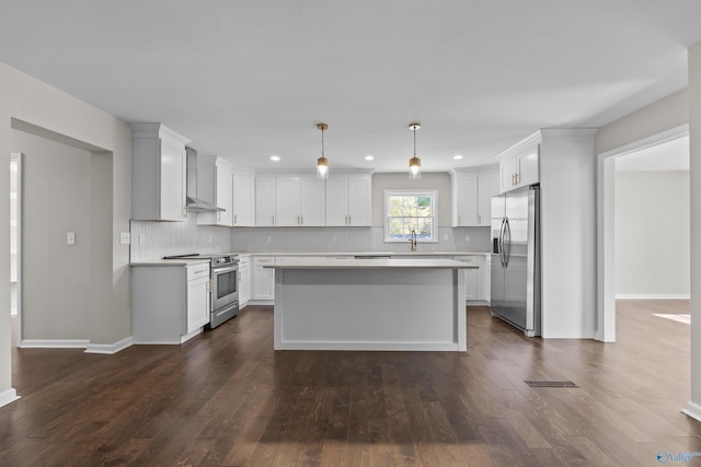 kitchen with stainless steel appliances, light countertops, a sink, dark wood-type flooring, and decorative backsplash