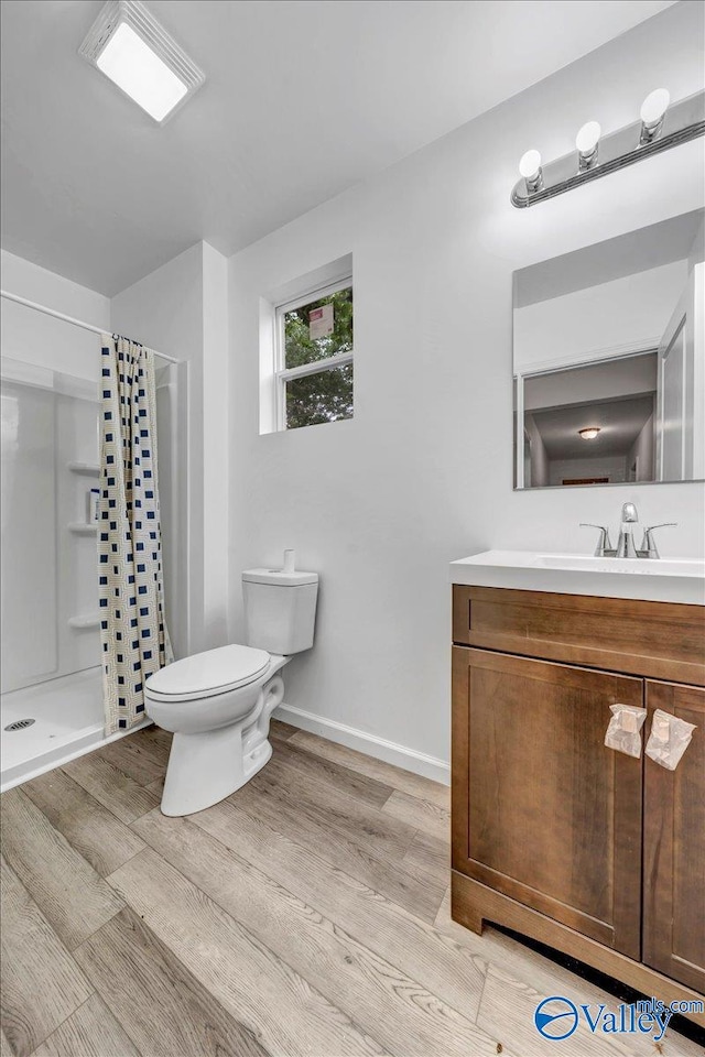 bathroom with vanity, toilet, curtained shower, and hardwood / wood-style floors