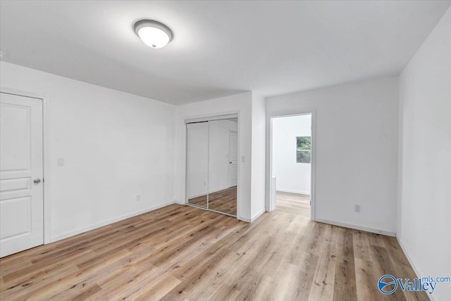 unfurnished bedroom featuring light hardwood / wood-style floors and a closet