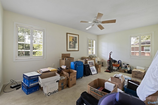 interior space featuring ceiling fan, light colored carpet, and plenty of natural light