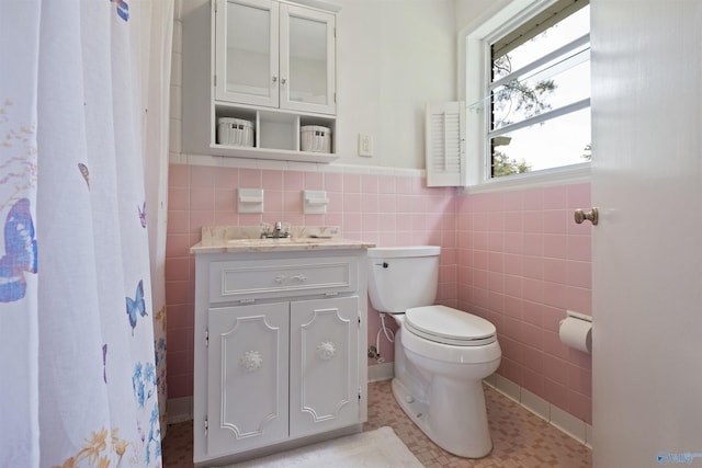 bathroom with tile walls, vanity, tile patterned floors, and toilet