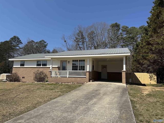 ranch-style house featuring an attached carport, driveway, crawl space, brick siding, and metal roof