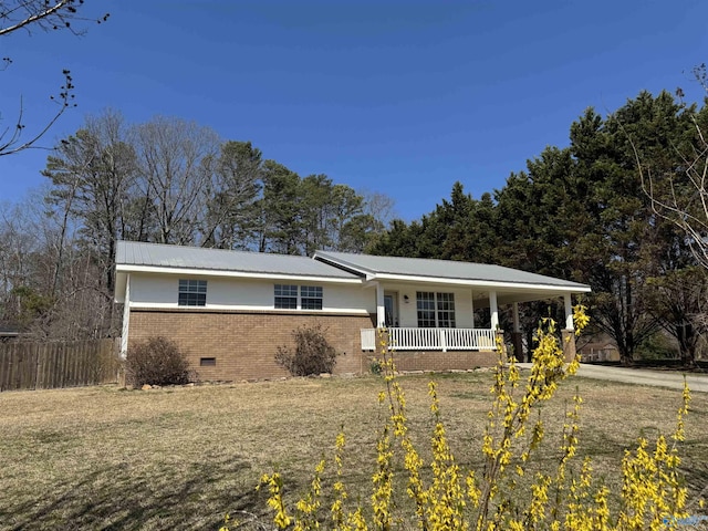 ranch-style home featuring brick siding, fence, a porch, metal roof, and crawl space