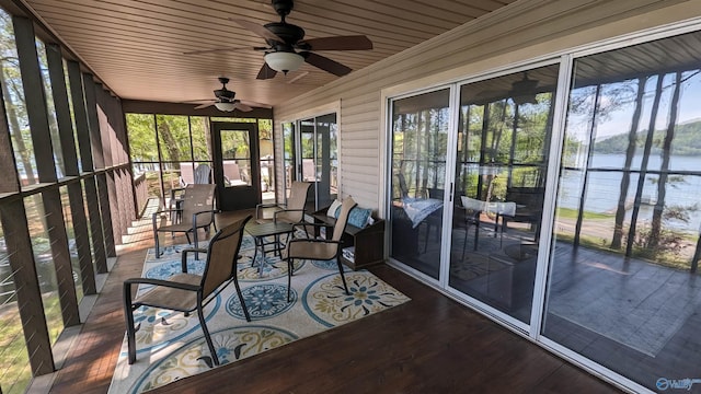 unfurnished sunroom with wooden ceiling, ceiling fan, and a water view