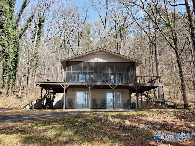 rear view of property with a sunroom and a deck