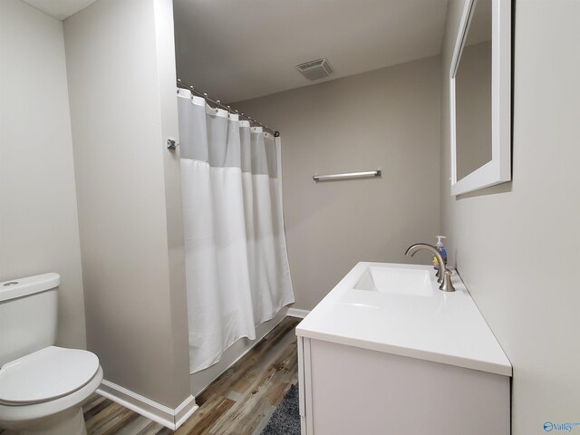 bathroom with a shower with shower curtain, vanity, toilet, and hardwood / wood-style floors