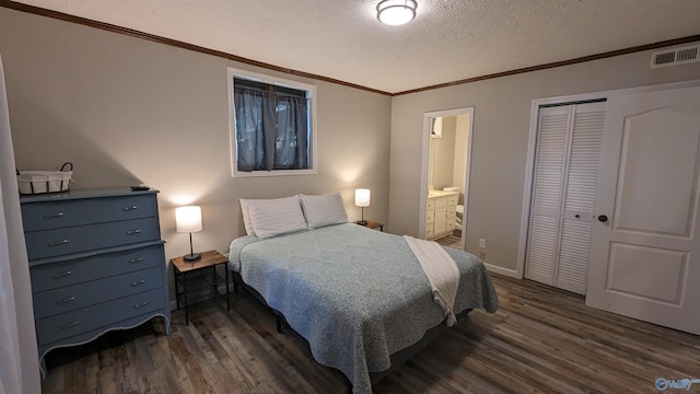 bedroom with ensuite bathroom, dark hardwood / wood-style flooring, a textured ceiling, and a closet