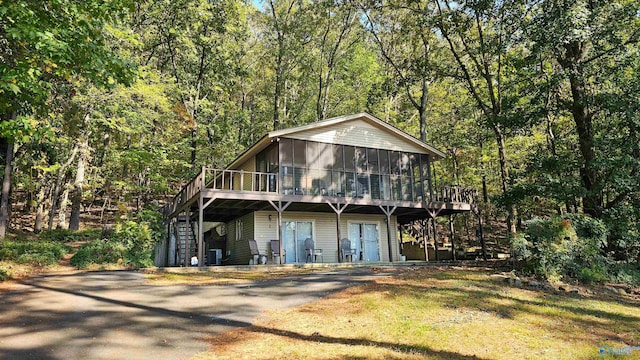 view of front of house with a wooden deck, a sunroom, and central air condition unit