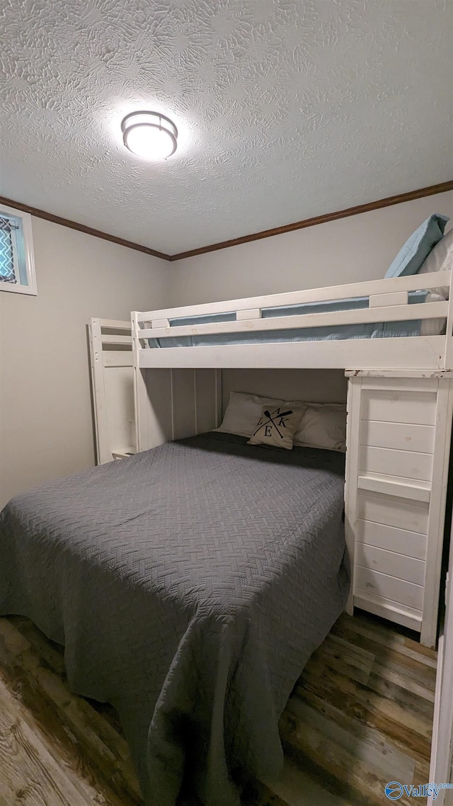 bedroom with a textured ceiling and dark hardwood / wood-style flooring