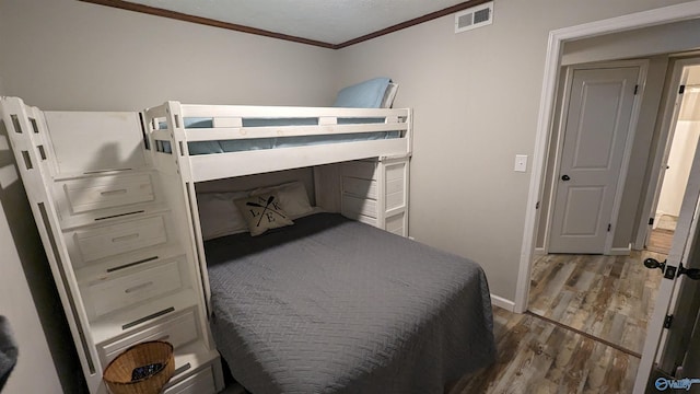 bedroom featuring hardwood / wood-style flooring and crown molding