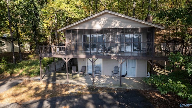 back of property featuring a patio, a sunroom, and a deck