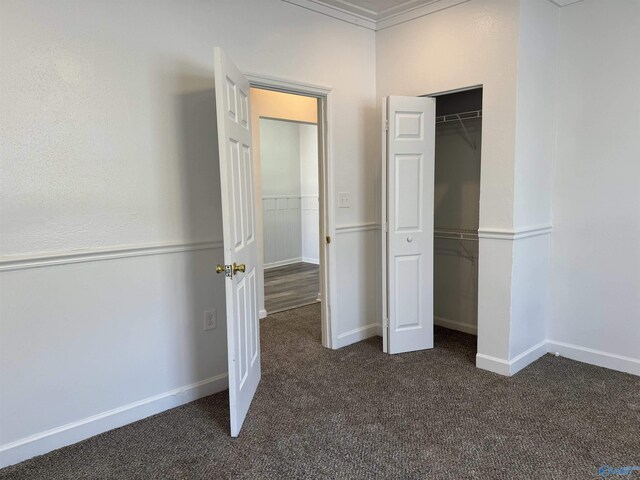 unfurnished bedroom with crown molding, a closet, and carpet floors