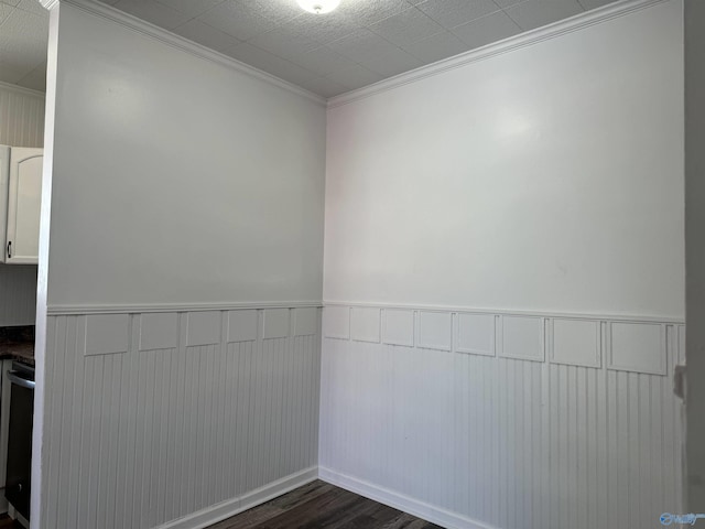 spare room featuring dark wood-type flooring and ornamental molding