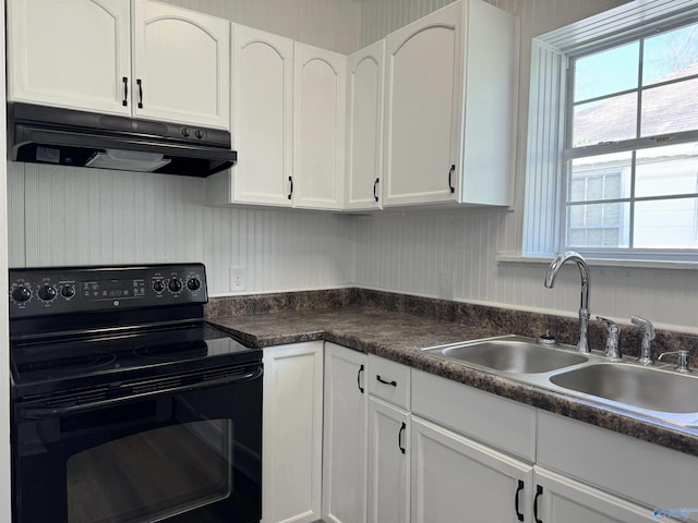 kitchen featuring black range with electric stovetop, sink, and white cabinets