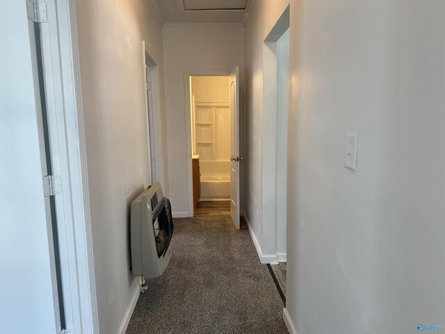 hallway featuring dark carpet and heating unit