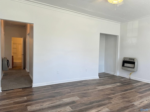 unfurnished room with ornamental molding, heating unit, and dark hardwood / wood-style flooring