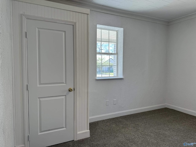 unfurnished room featuring crown molding and dark colored carpet