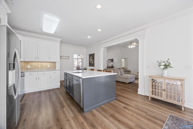 kitchen with white cabinets, stainless steel appliances, light countertops, and a sink