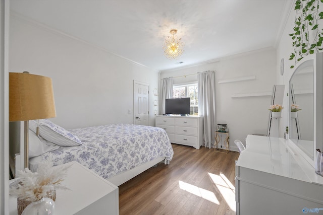 bedroom with a notable chandelier, wood finished floors, and ornamental molding