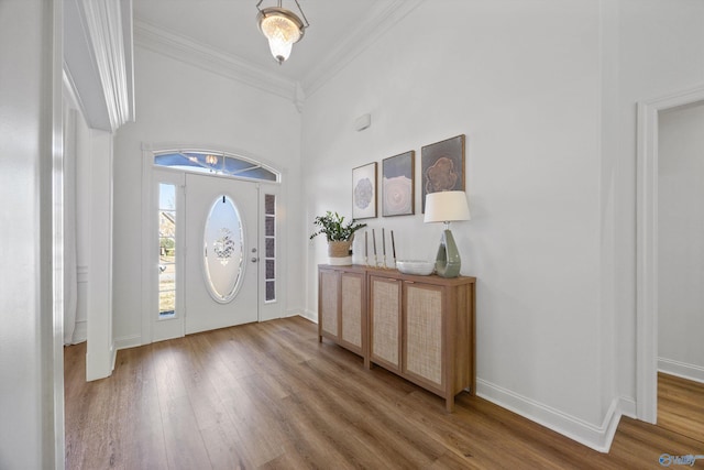 entryway featuring a healthy amount of sunlight, crown molding, baseboards, and wood finished floors