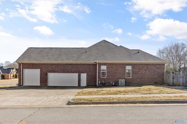 view of side of home with brick siding, a shingled roof, concrete driveway, cooling unit, and an attached garage