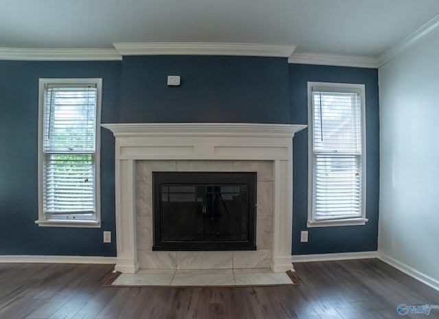 room details with hardwood / wood-style floors, crown molding, and a tile fireplace